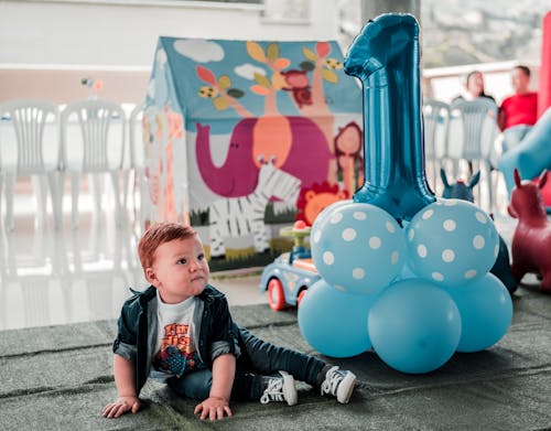 Free Boy Sitting on Floor With Balloons Stock Photo
