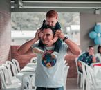 Shallow Focus Photo of Man Carrying His Child on His Neck