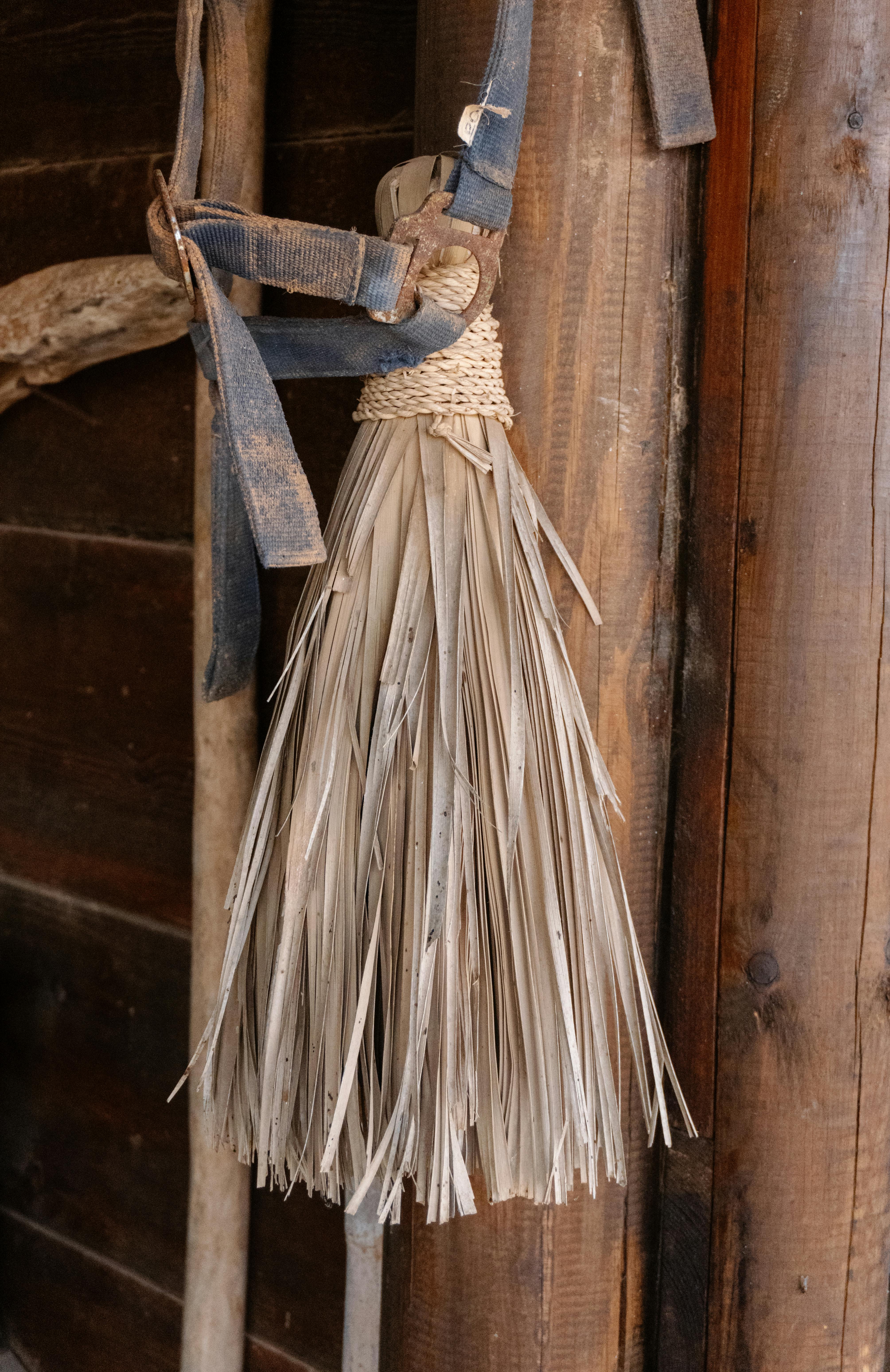 Gratuit Gros plan sur un balai rustique en paille, fait main, accroché à un mur en bois, créant une ambiance vintage. Photos