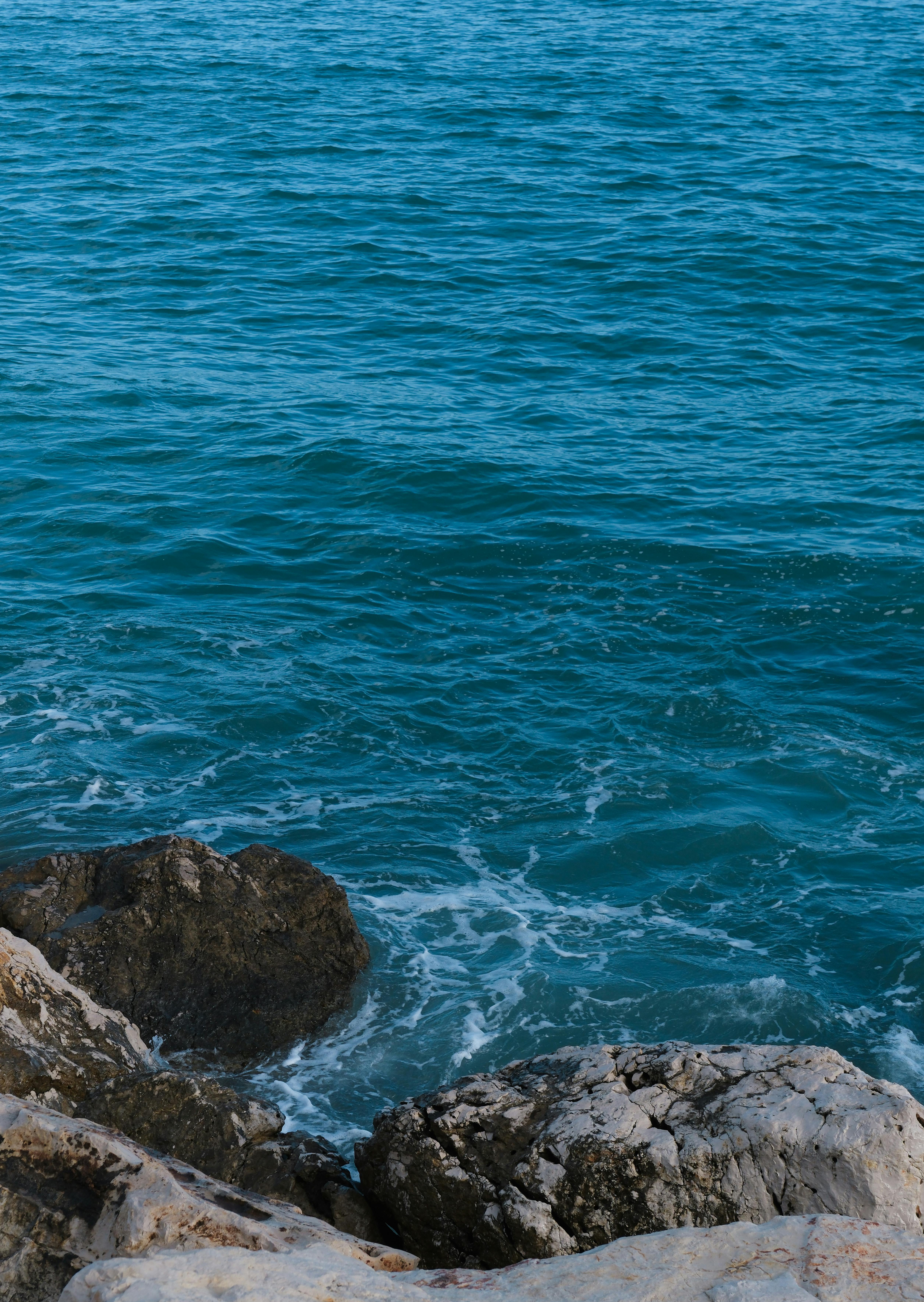 Gratis Vista serena de las olas del océano rompiendo contra la costa rocosa, capturando la tranquilidad costera. Foto de stock