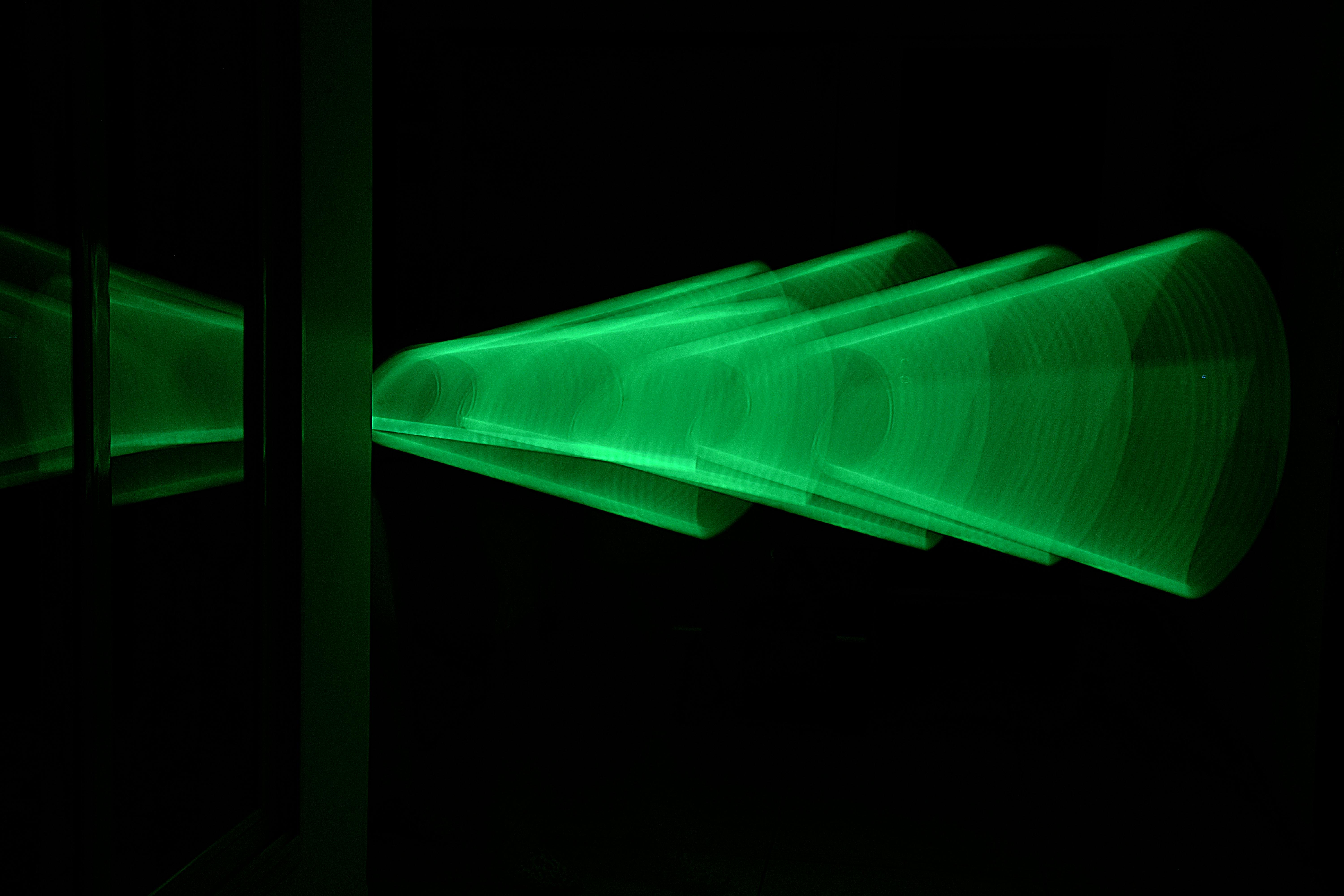 Gratis Immagine astratta che mostra scie di luce verde brillante riflesse in una stanza buia, creando un motivo futuristico. Foto a disposizione