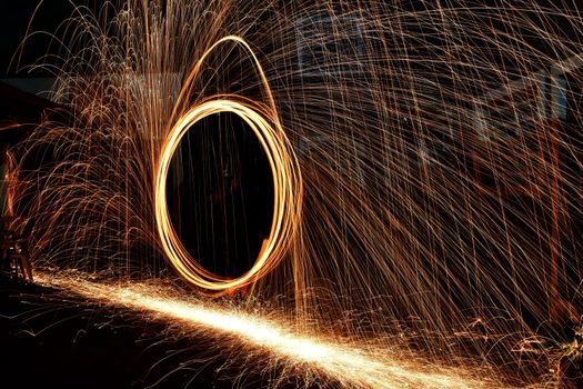 Dazzling display of light and motion with steel wool sparks captured at night.