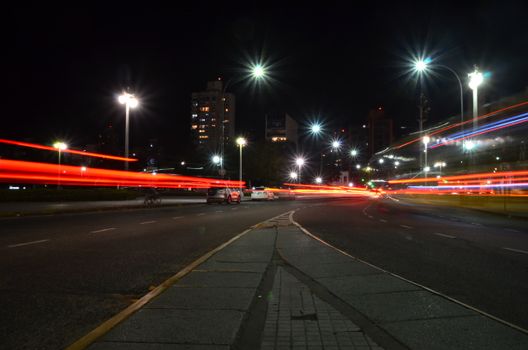 Dynamic city nightscape capturing vibrant light trails from moving cars on a city street.