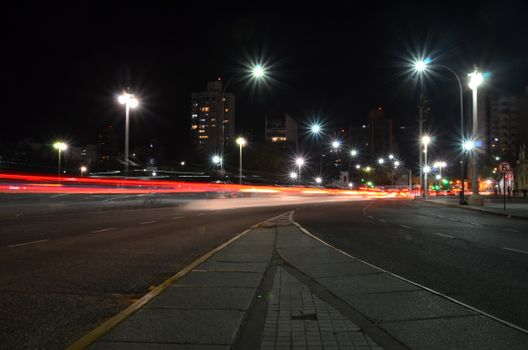 Vibrant urban night scene with light trails capturing motion on a city street.