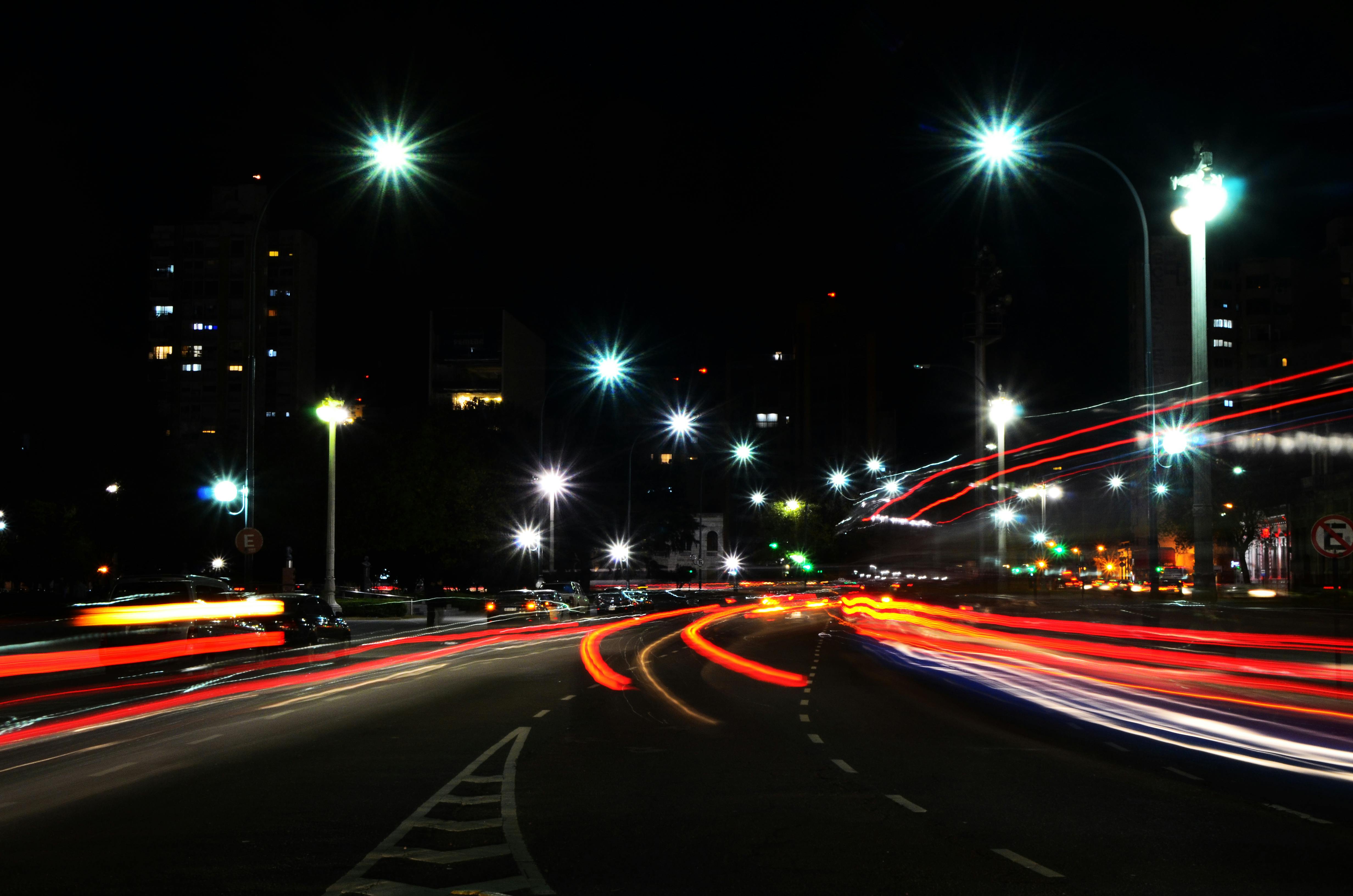 無料 活気に満ちた都市の夜景。賑やかな街路に車のライトの軌跡が映し出されている。 写真素材