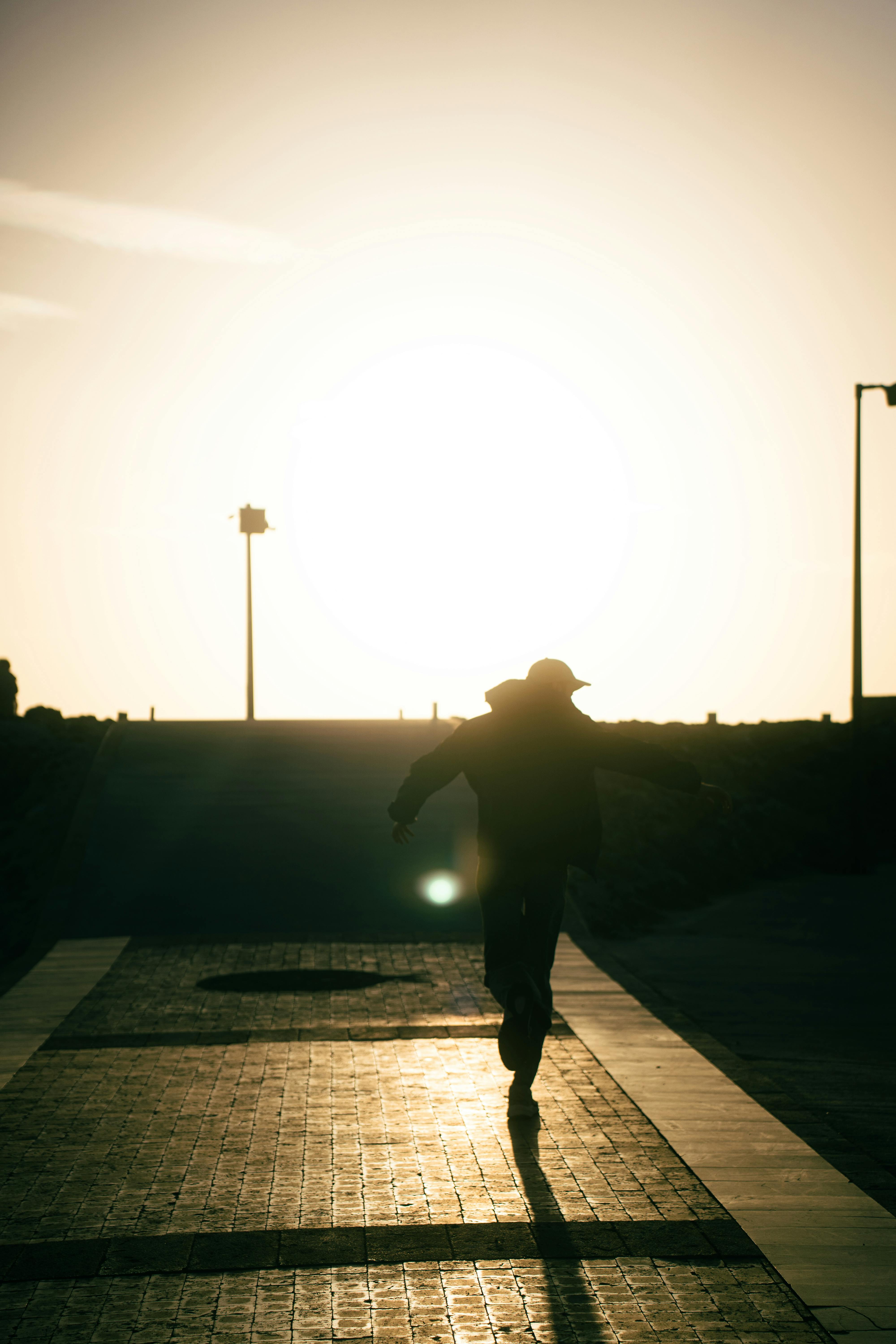 Bezpłatne Dramatyczna sylwetka człowieka biegnącego o zachodzie słońca w Antalyi, Turcja. Zdjęcie z galerii