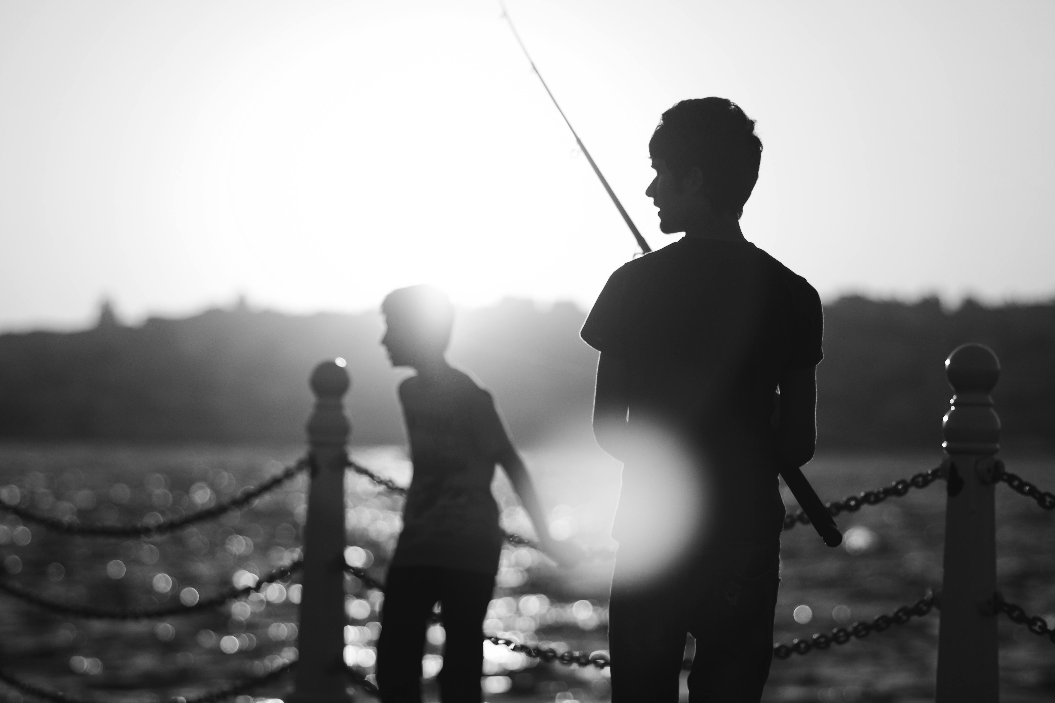bezplatná Siluety teenagerů rybařících a zachycujících klidné západy slunce u istanbulského nábřeží. Základová fotografie