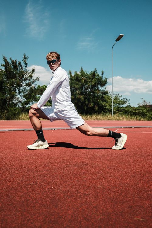 Free Young athlete stretching on a sunny outdoor track in Taytay, Philippines. Stock Photo