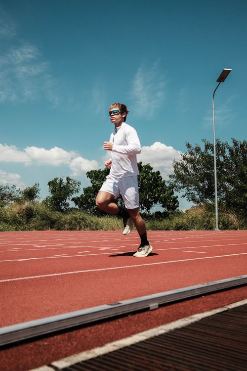 Free Athlete jogging on an outdoor track in Taytay, showcasing fitness and determination. Stock Photo