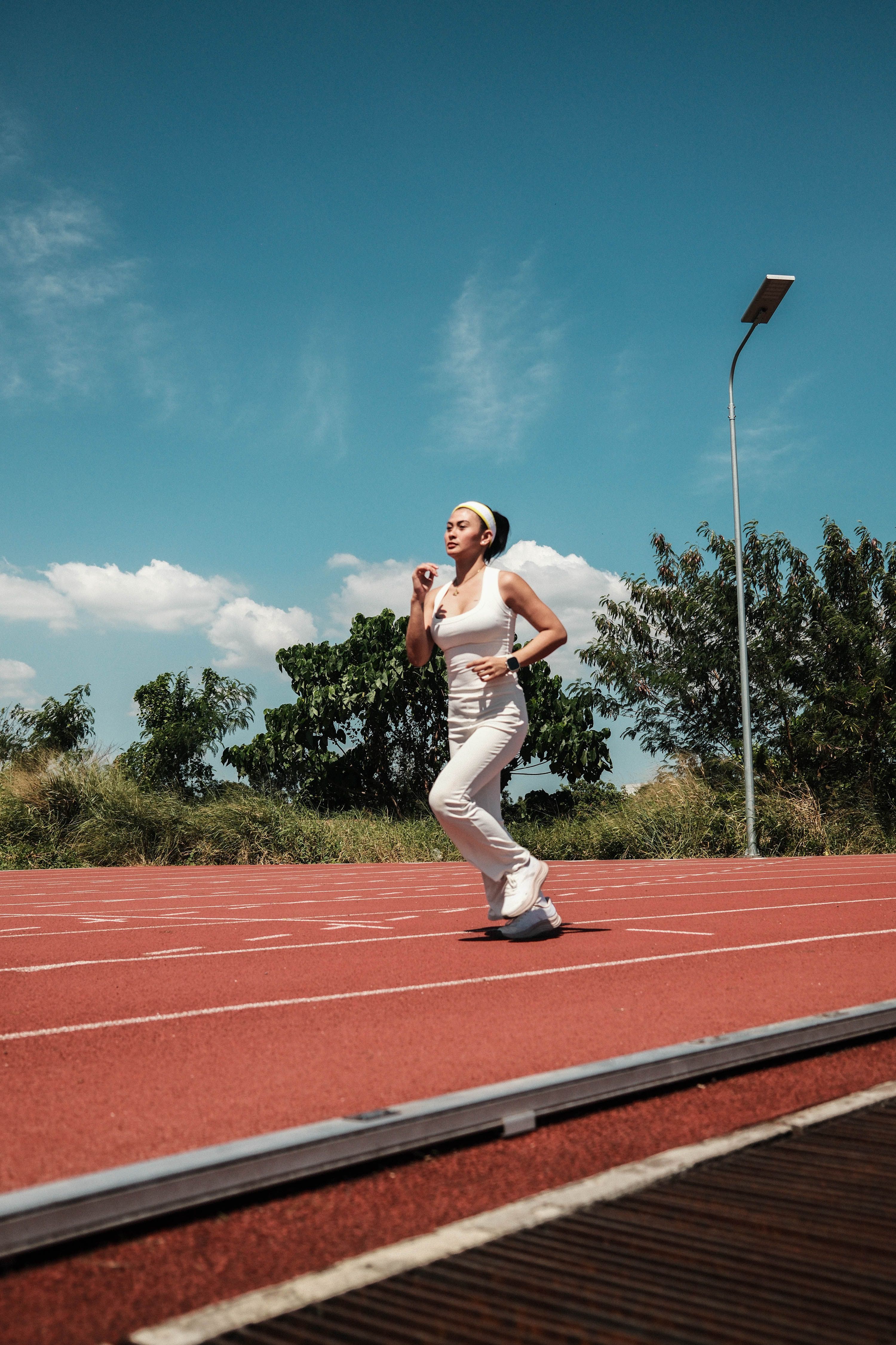 Female Athlete Running on Outdoor Track · Free Stock Photo