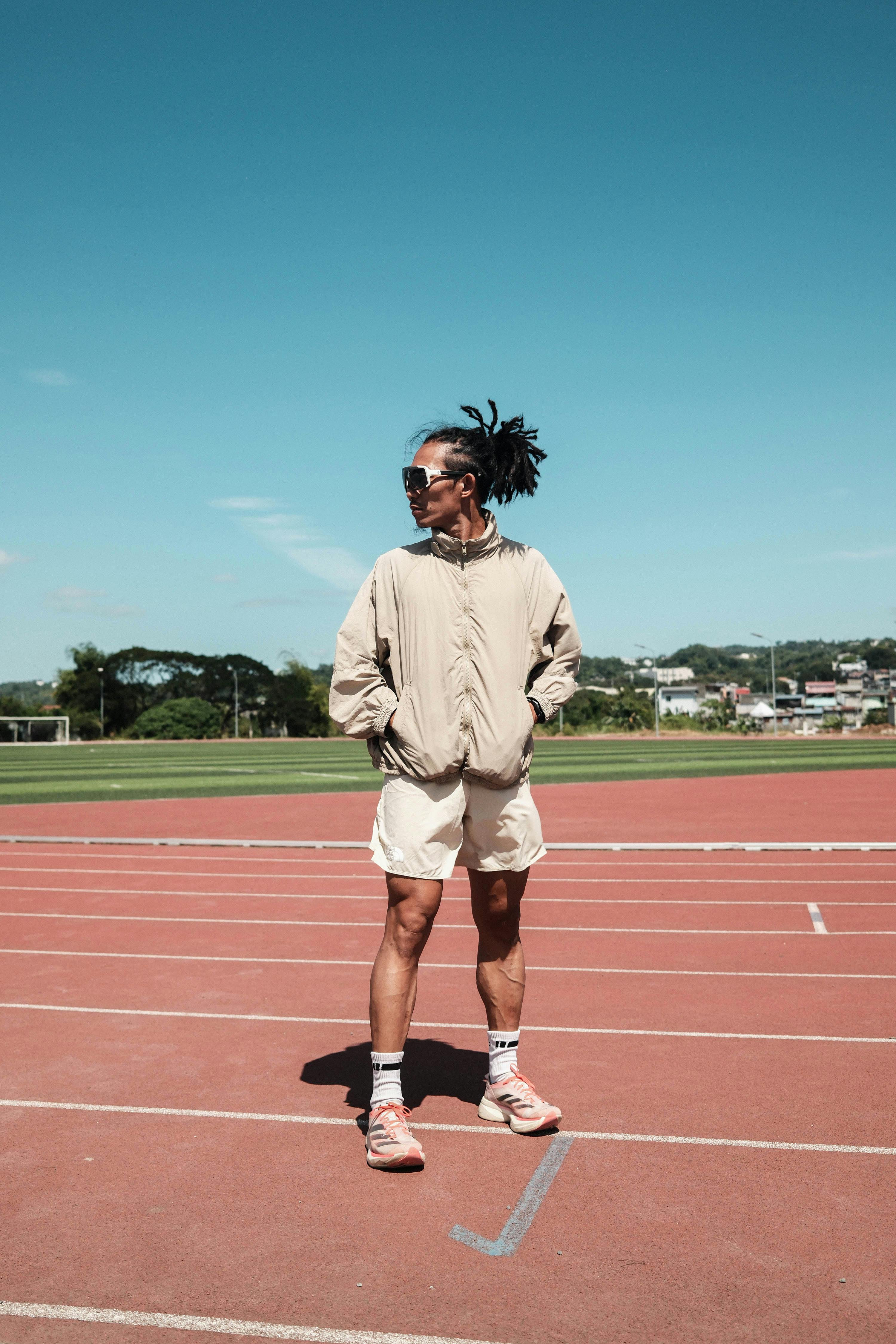 De franc Un atleta amb roba esportiva informal es manté amb confiança en una pista assolellada a Taytay, Calabarzon, Filipines. Foto d'estoc