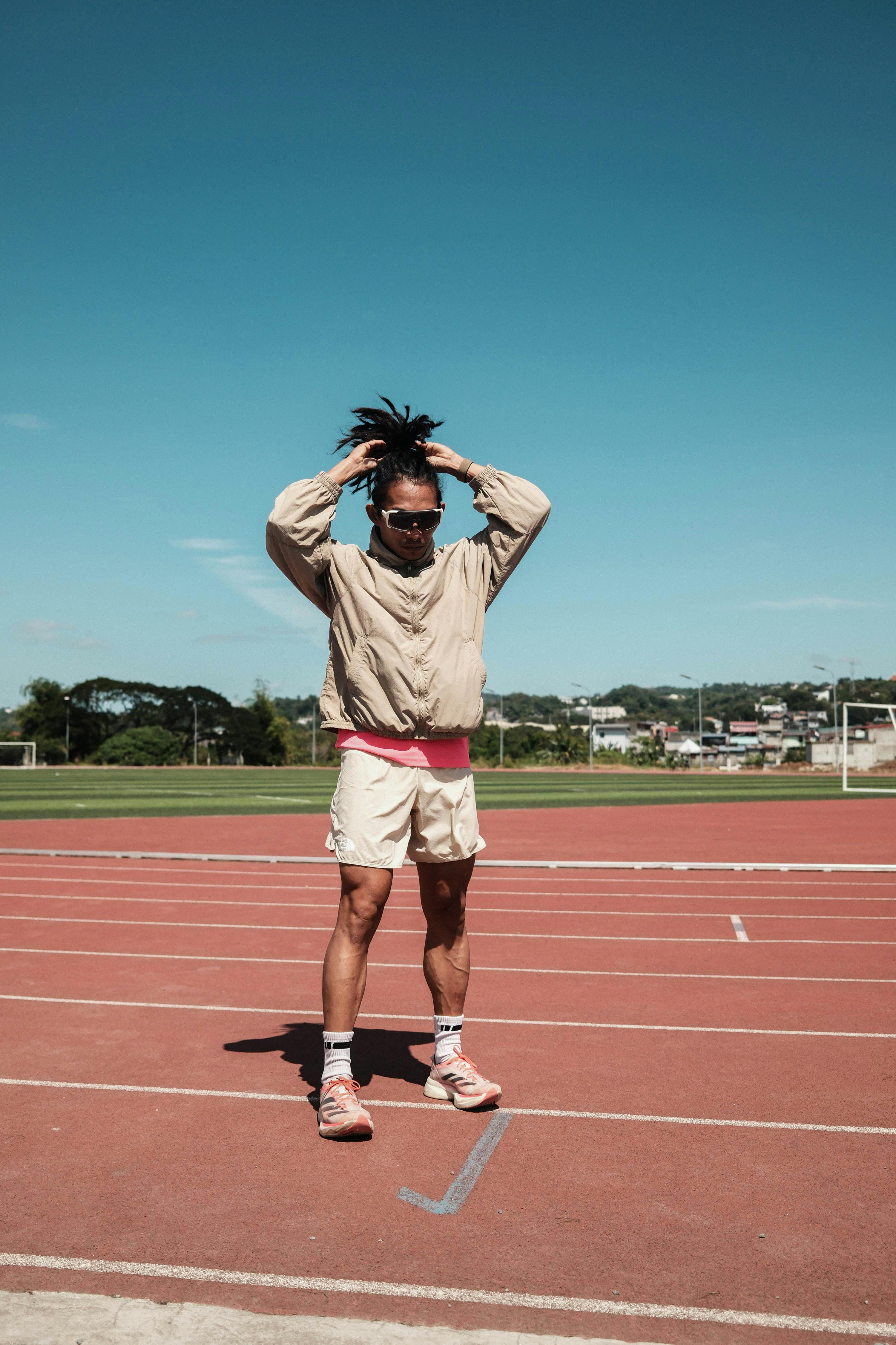 grátis Atleta se prepara em um dia ensolarado em uma pista de atletismo ao ar livre em Taytay, Filipinas. Foto profissional