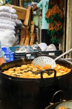 Fried snacks being prepared in a street food stall in Dhaka's bustling bazaar.