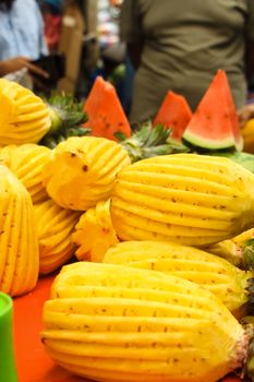 Bright display of freshly cut pineapples and watermelon slices at a vibrant Dhaka market.