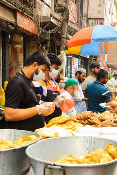 Street vendors serving traditional food in a bustling Dhaka market