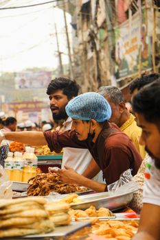 Vibrant street market scene in Dhaka with vendors and diverse food offerings.
