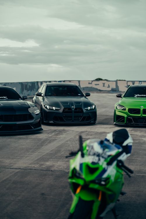 Free Dynamic scene of sports cars and motorcycle on a rooftop under cloudy sky. Stock Photo