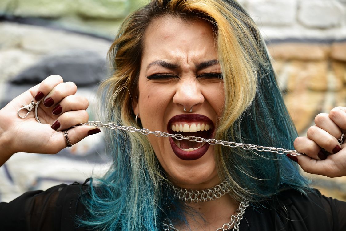 Edgy Portrait of Woman Biting Chain · Free Stock Photo