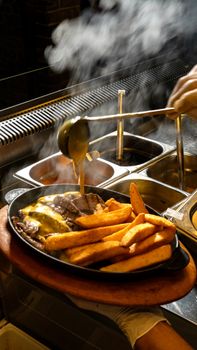 Delicious steak served with golden fries and rich gravy being poured, capturing a warm dining experience.