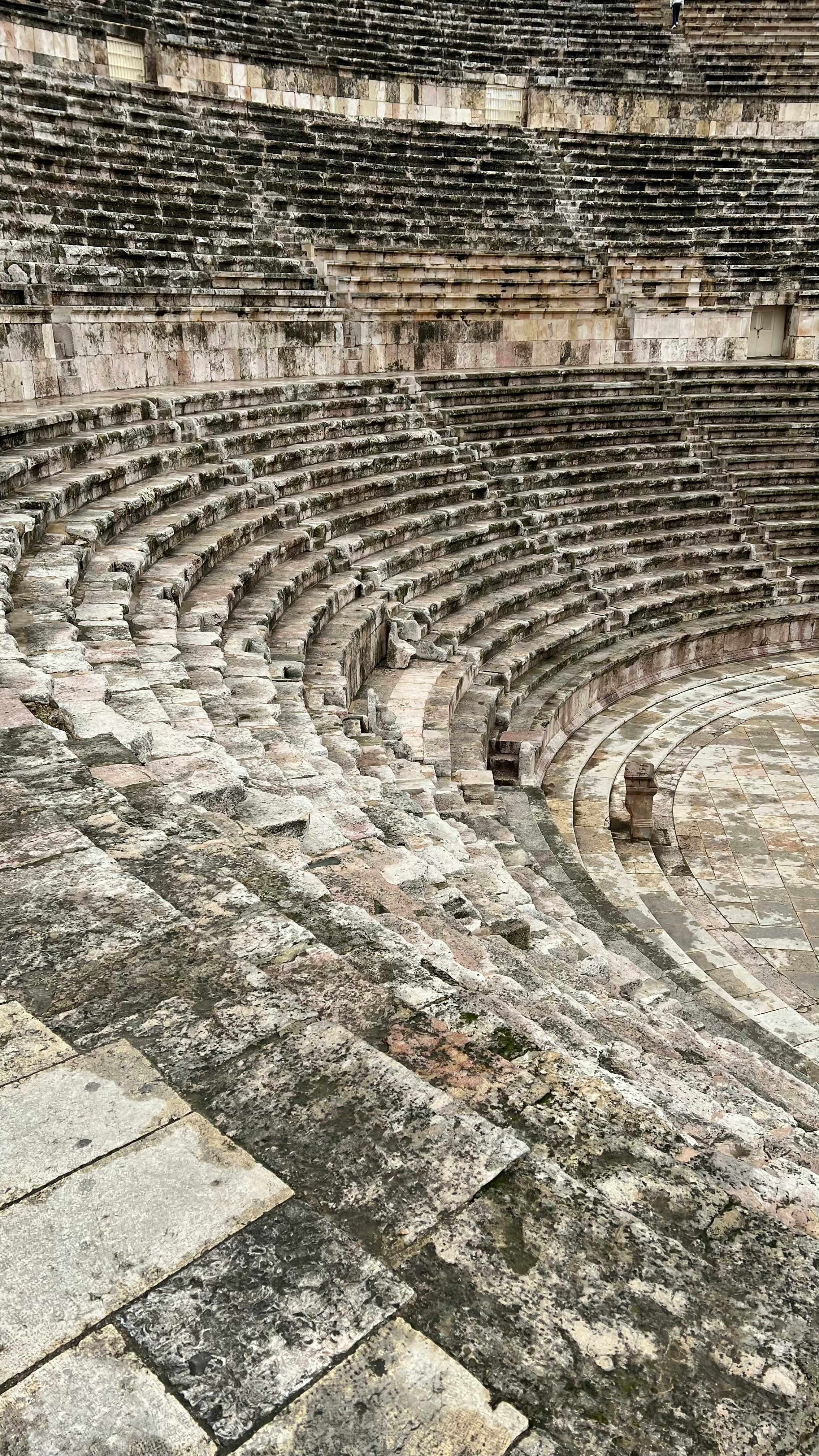 Explore the historic ruins of a Roman amphitheater in Jordan, showcasing stunning stone architecture.