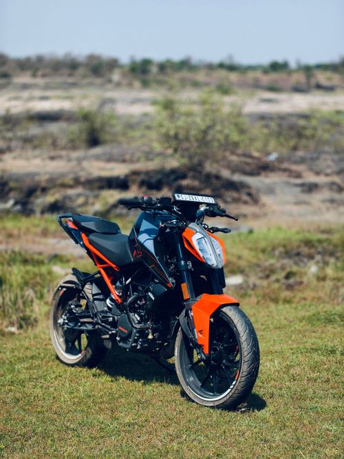 Free A vibrant sport motorcycle parked on a grassy field against a rugged landscape in Kakrapar, India. Stock Photo