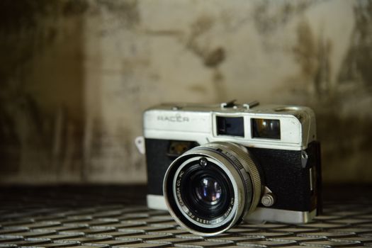 A classic vintage film camera resting on a rustic surface, showcasing retro charm.