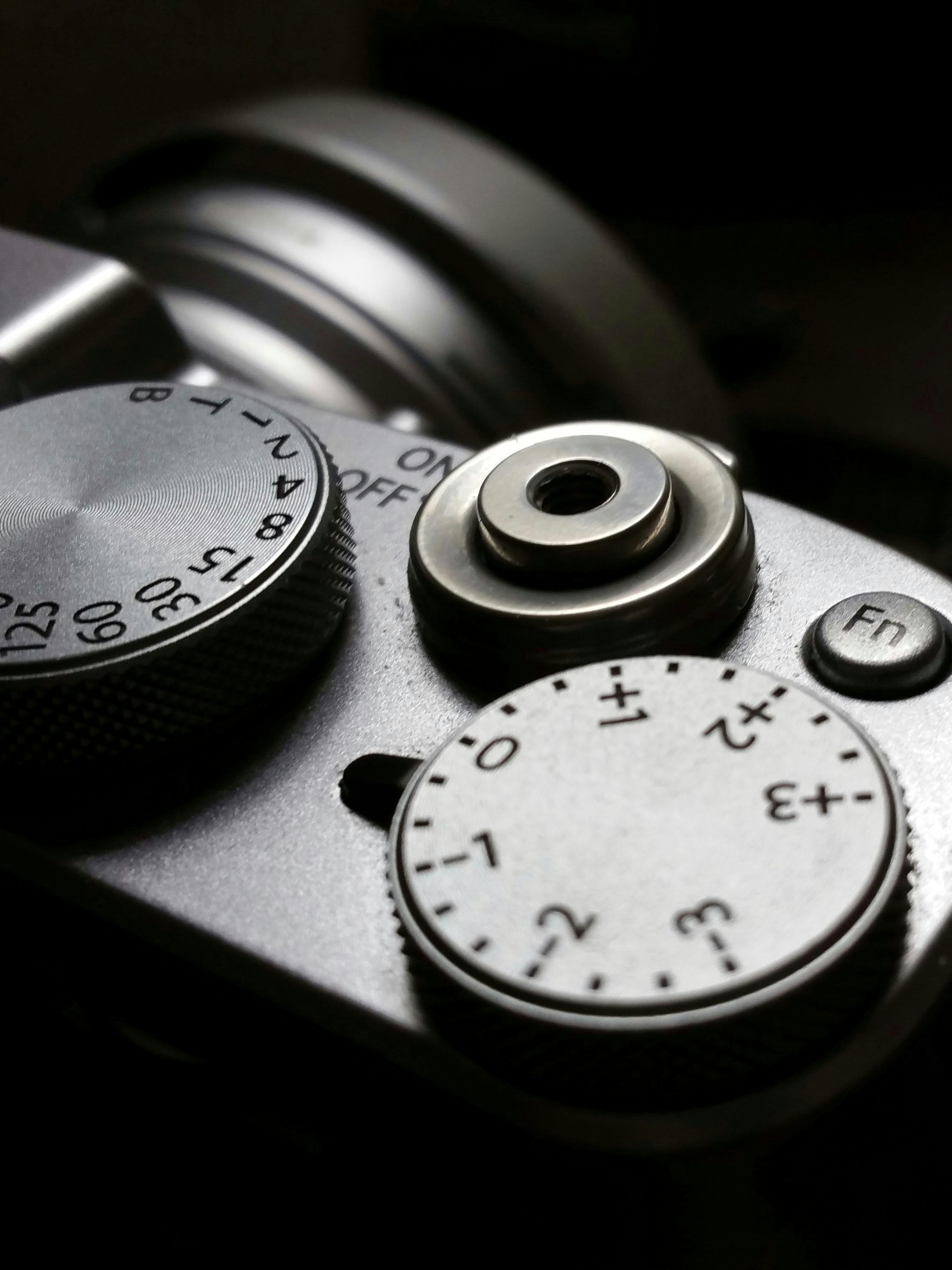 bezplatná Detailní snímek zobrazující voliče a ovládací prvky fotoaparátu ve vintage stylu s důrazem na jeho propracovaný design. Základová fotografie