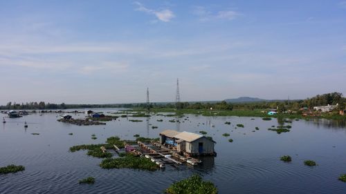 Free Floating houses on Mekong River with lush vegetation and clear sky in Vietnam. Stock Photo