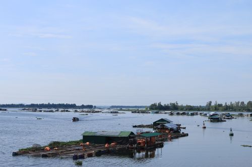 Free Serene view of floating houses on the Mekong River in Vietnam under a clear blue sky. Stock Photo