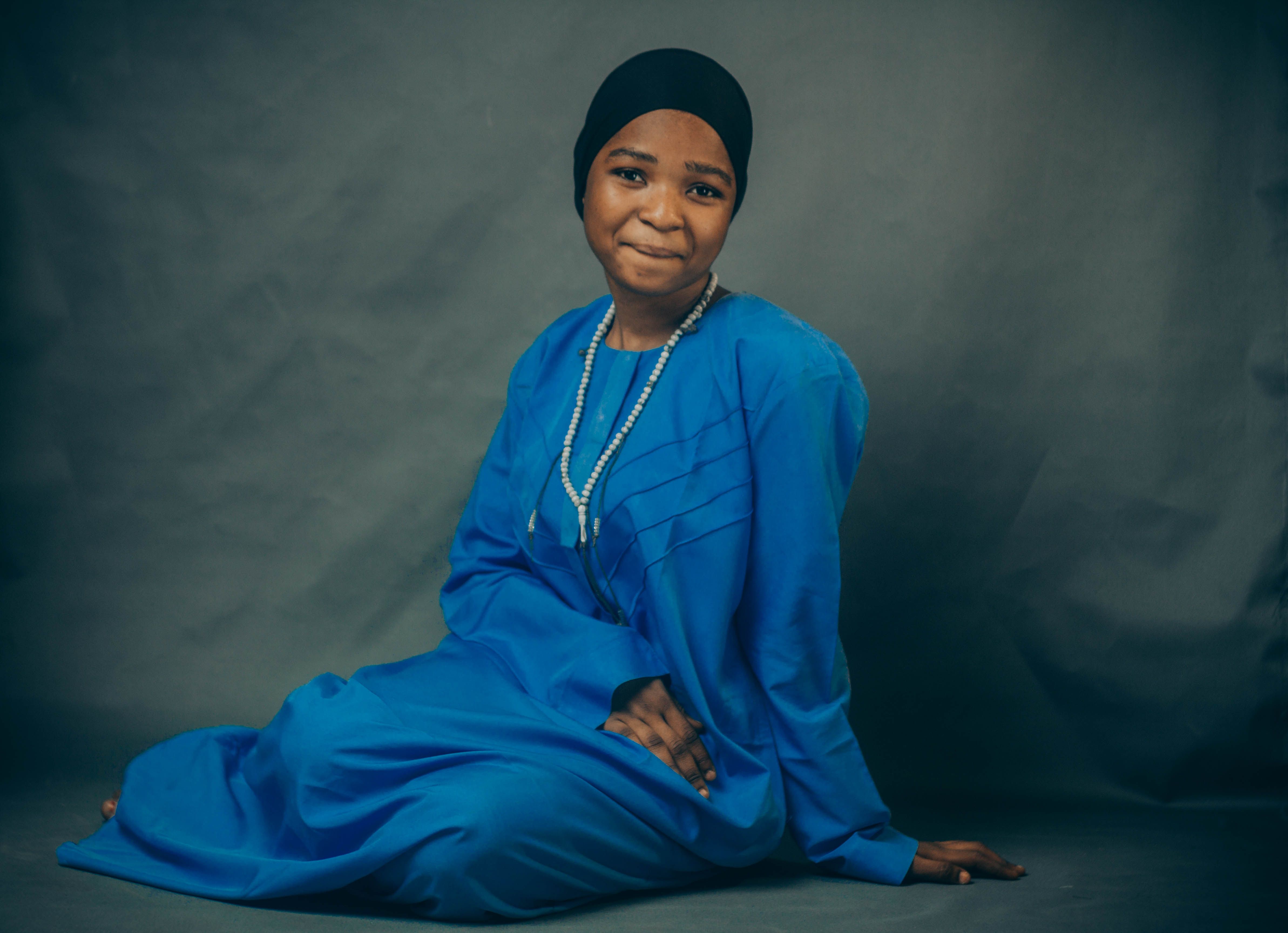 A serene portrait of a woman in traditional blue dress, indoors.