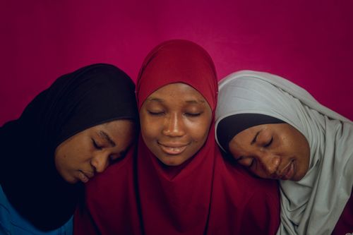 Free Three women in colorful hijabs share a serene moment together, symbolizing unity and peace. Stock Photo