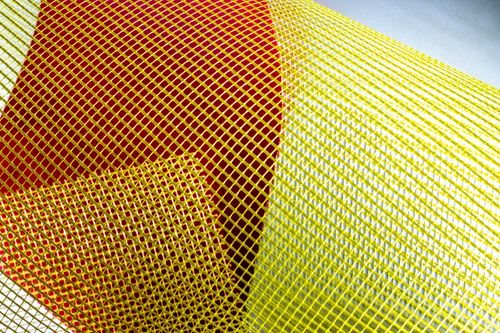 Free Close-up of a colorful mesh pattern featuring yellow and red hues, creating a vibrant abstract texture. Stock Photo