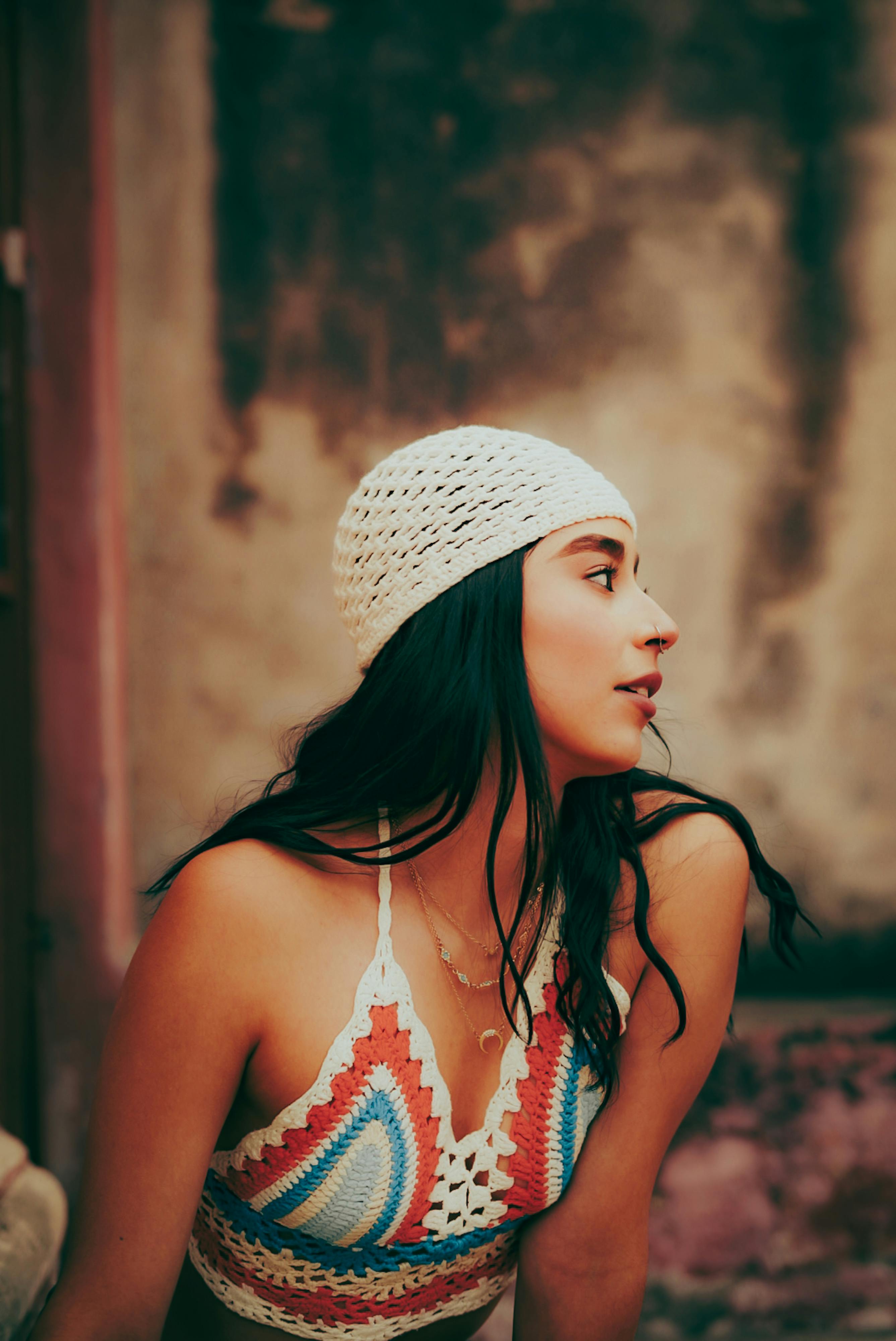 Ücretsiz Modern tarzı sergileyen, bohem tığ işi bir bluz ve bere takan şık bir kadının portresi. Stok Fotoğraflar