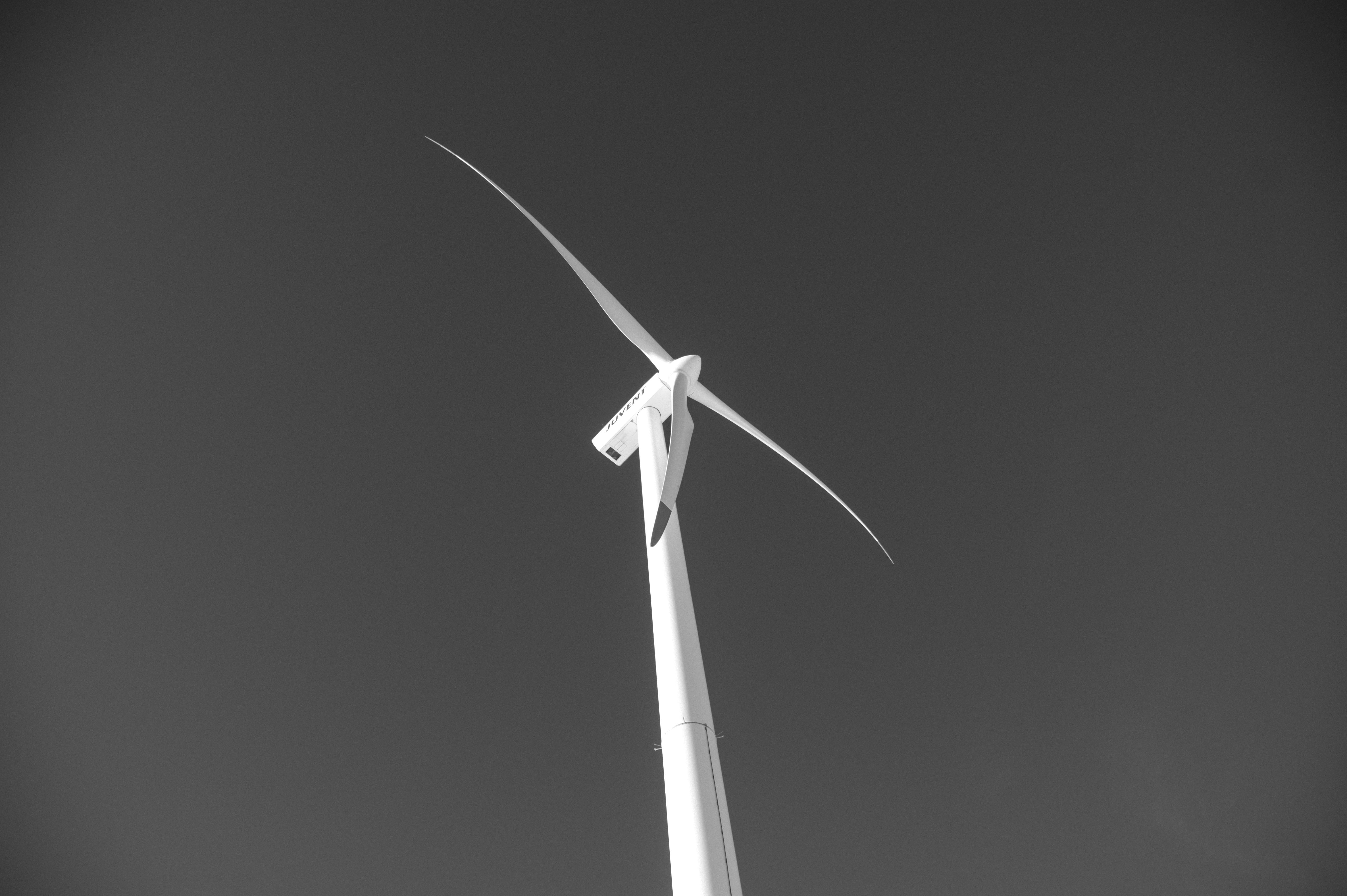 Gratis Spettacolare prospettiva in bianco e nero di un'imponente turbina eolica contro un cielo limpido. Foto a disposizione