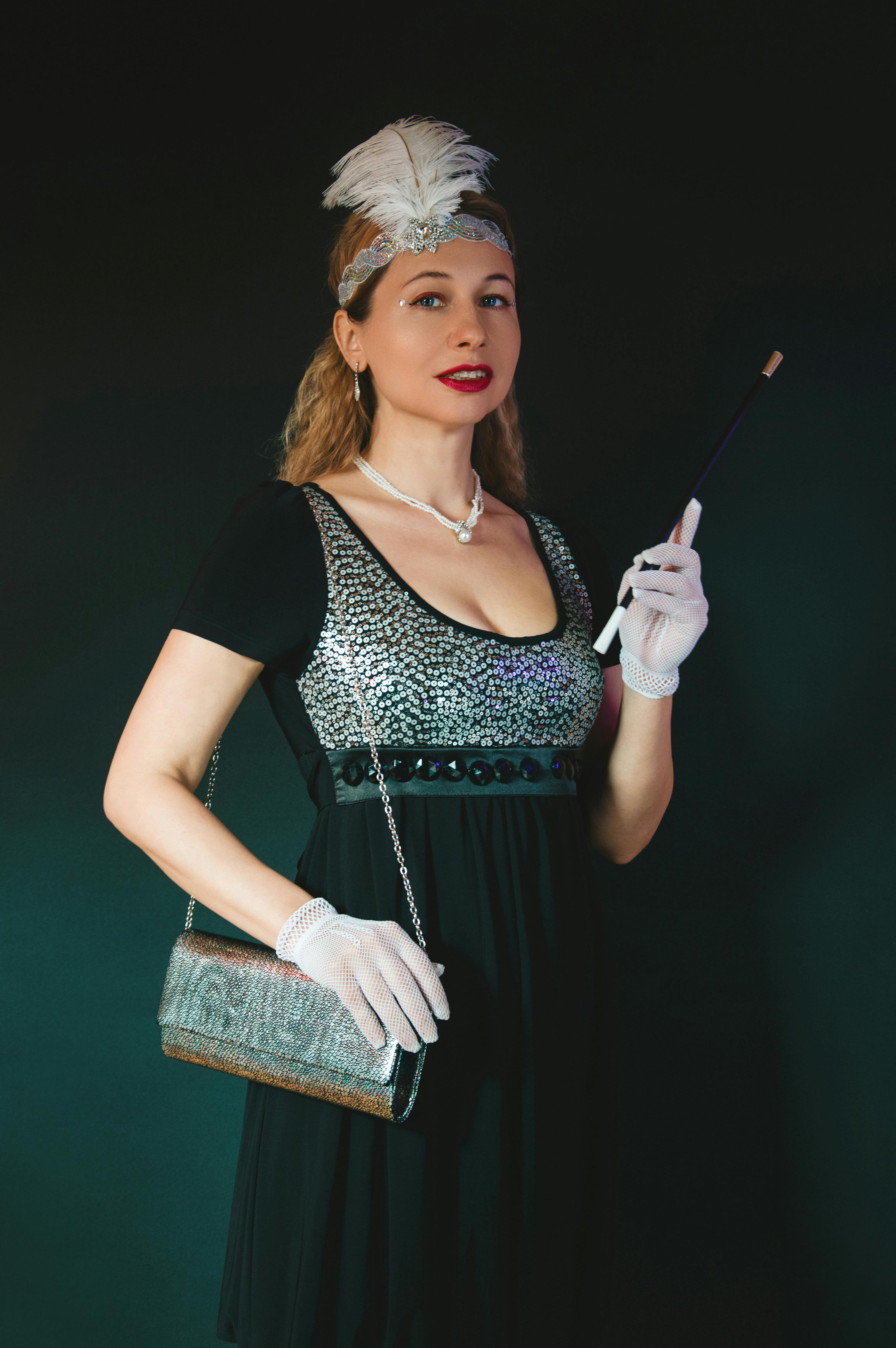 grátis Mulher vestida com um traje vintage estilo melindrosa dos anos 1920, com acessórios, posando contra um fundo escuro. Foto profissional