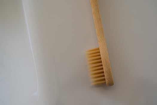 Close-up of a bamboo toothbrush on a plain white background, highlighting sustainable dental care.