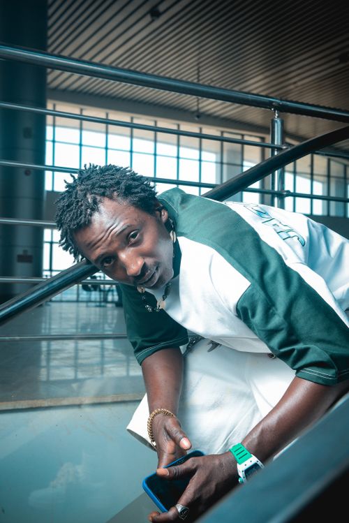 Free Man casually leaning on railing indoors, urban lifestyle vibe. Stock Photo