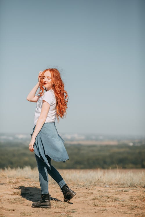 Woman Standing on Brown Grass Field