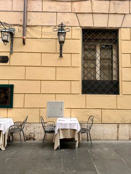 Cozy outdoor cafe scene in Rome, showcasing Italian architecture and charm.