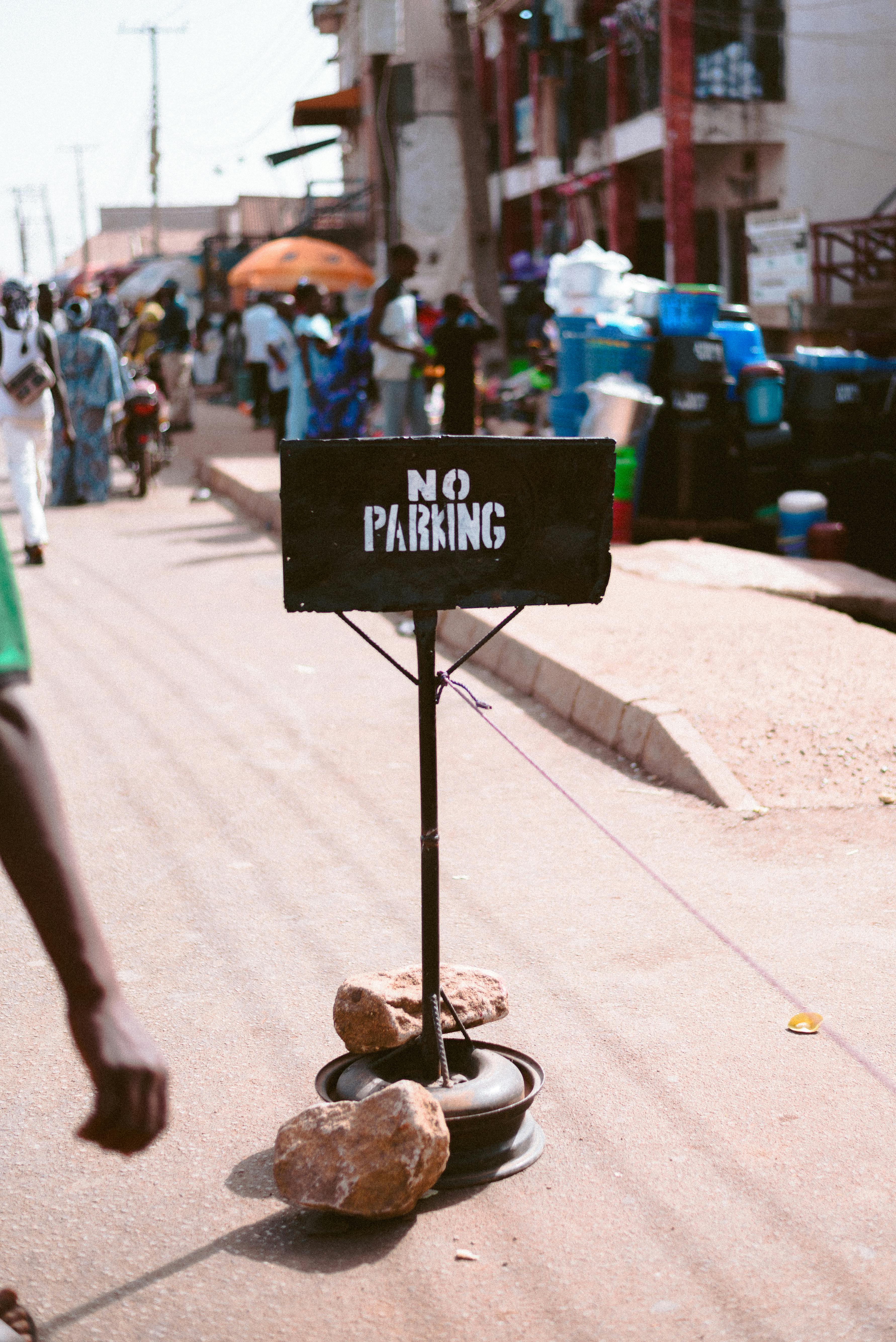 Kostenlos Lebhaftes Straßenmarkt-Geschehen auf dem Jos-Plateau in Nigeria mit einem „Parken verboten“-Schild und regem Treiben. Stock-Foto