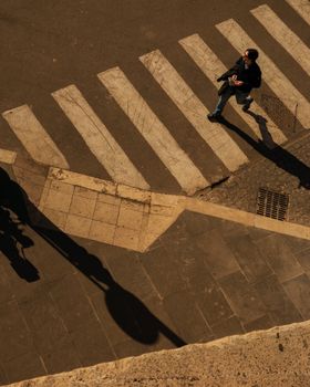 Aerial view of a pedestrian crossing in Lazio, Italy, taken in daylight, capturing urban life.