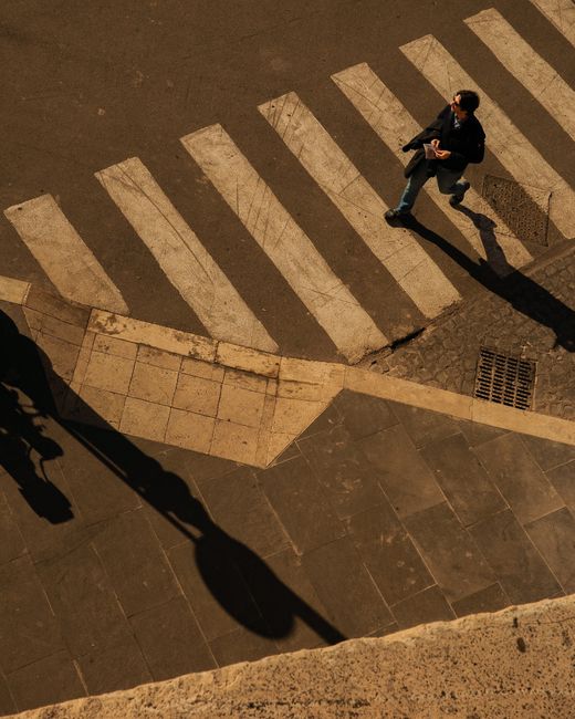 Aerial view of a pedestrian crossing in Lazio, Italy, taken in daylight, capturing urban life.