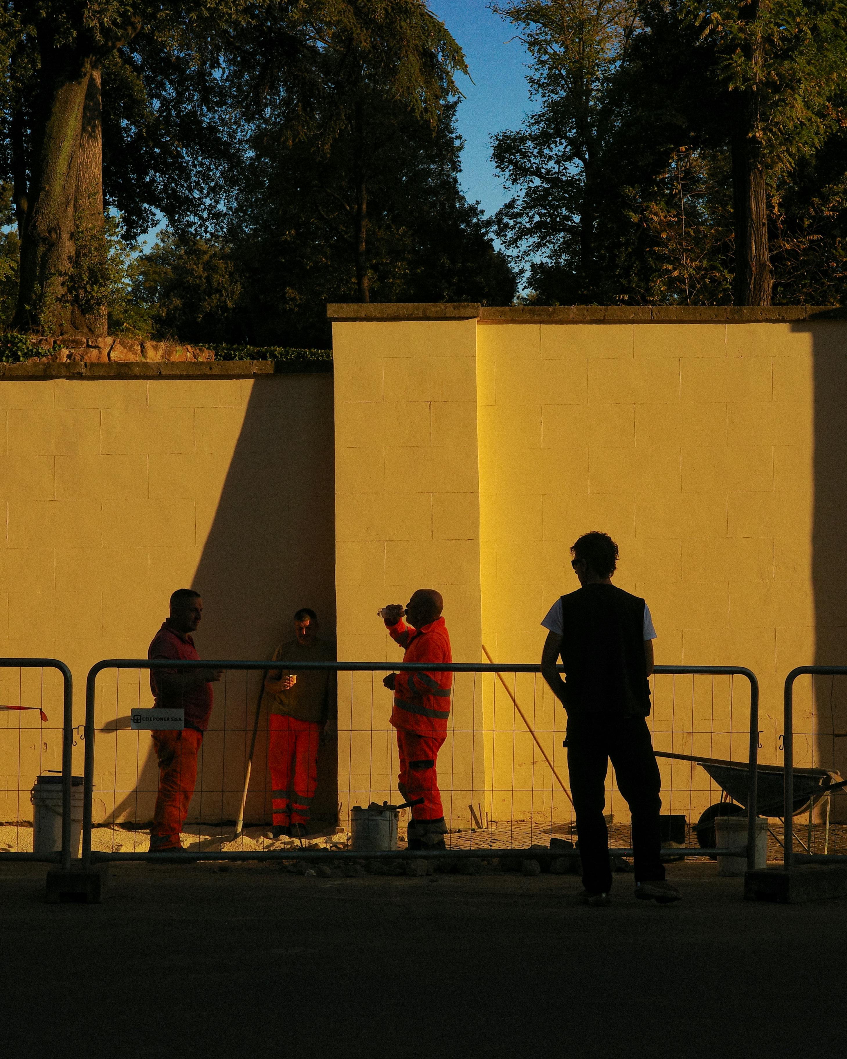 Ücretsiz İtalya'nın Lazio bölgesinde, gün batımında bir inşaat sahasının yakınında işçiler sohbet ediyor. Stok Fotoğraflar