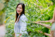 Smiling Woman in Garden with Lush Greenery