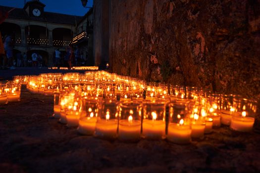A serene candlelit street scene during a night festival in Pedraza, Spain, with glowing candles lighting up the historic setting.