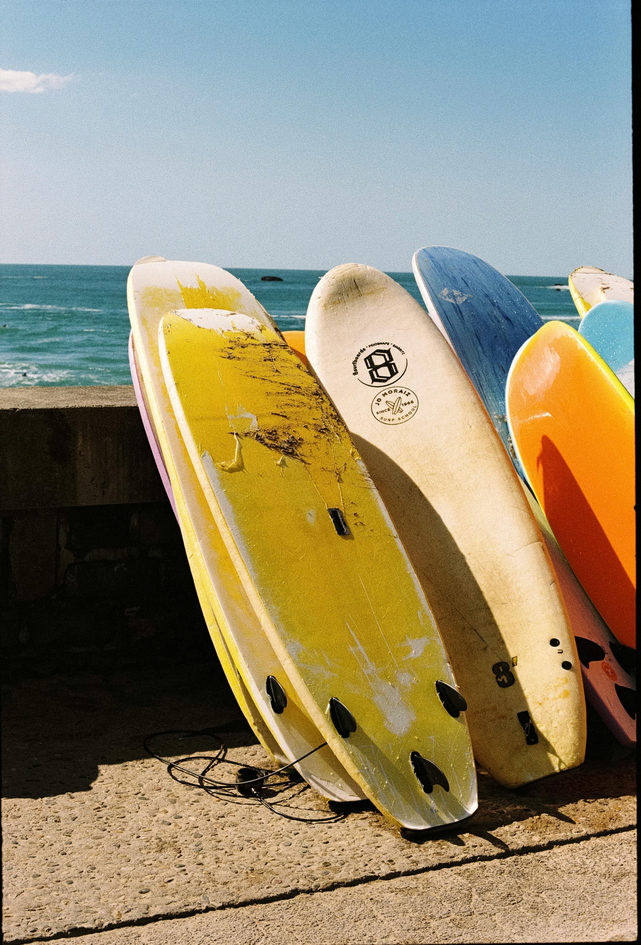 Vibrant surfboards lined up by the ocean in Biarritz, France, perfect for a summer adventure.
