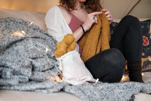 Femme Assise Sur Un Canapé En Tricotant Un Pull
