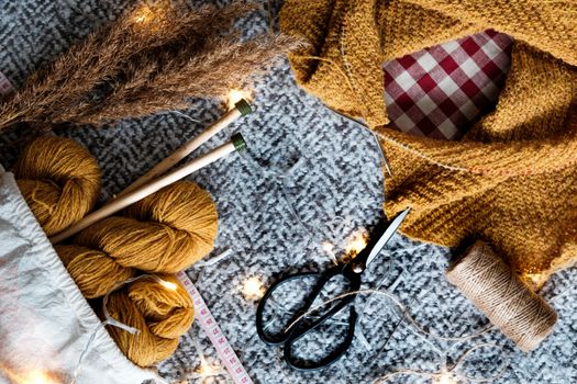 Discover cozy mustard yarn, knitting needles, and crafting tools in this inviting setup.