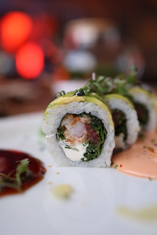 Free Close-up of a colorful sushi roll filled with fresh seafood and vegetables on a plate. Stock Photo