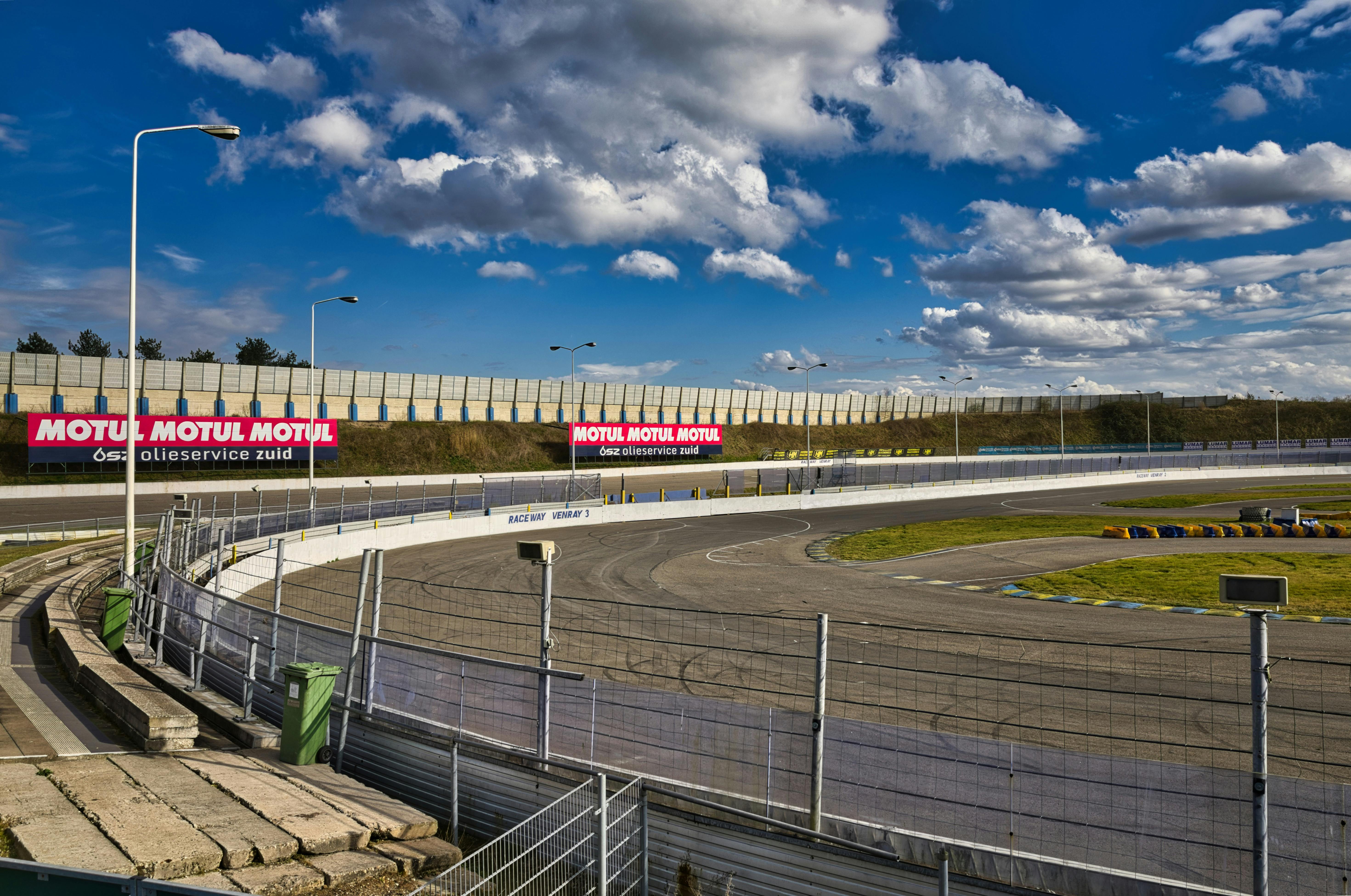 View of a deserted racetrack with clear skies and advertising banners.